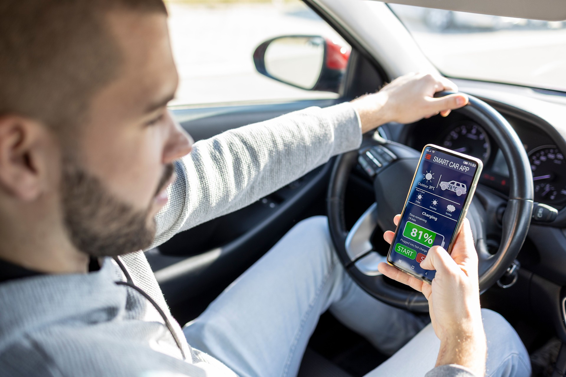 Man using mobile phone with smart car control functions